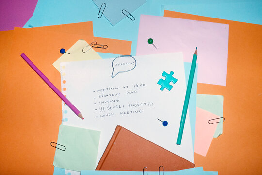 Colourful office supply and speech bubble paper clip saying attention