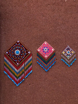 Vibrant Handcrafted Beaded Ornaments on Earthen Wall in Abyaneh