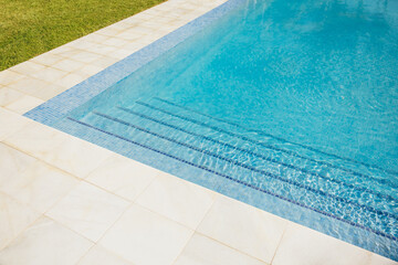 Bright sunny poolside with shimmering water