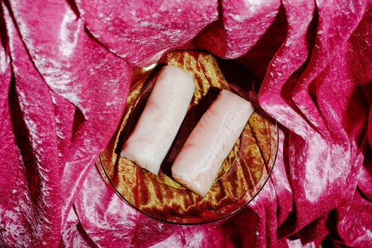 orange glass plate with a pair of hake loins