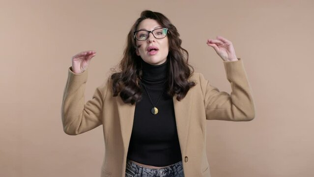 Mature woman makes fun of showing bla-bla gesture with hands on beige background