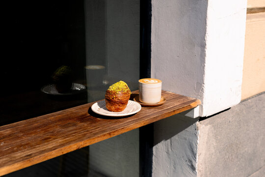Close-up shot captures a croissant and a specialty coffee