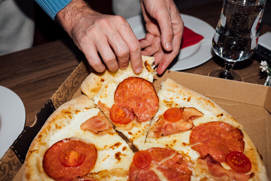 Anonymous person holding slice of delicious pizza. Finger, fast food.