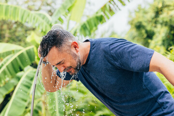 Man cooling off with water on a tropical sunny day
