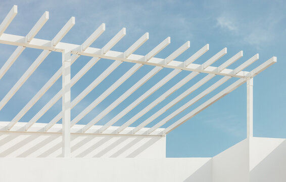 Modern white pergola against a blue sky