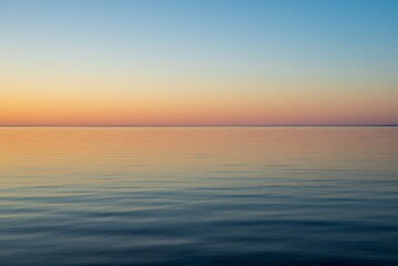 Sunset on a forest lake in the north of Finland. Calm lake water in the evening.