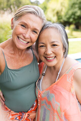 Diverse senior female friends smiling together outdoors