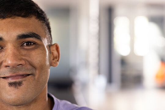 At gym rehabilitation center, biracial male patient wearing purple shirt, smiling, copy space - Powered by Adobe