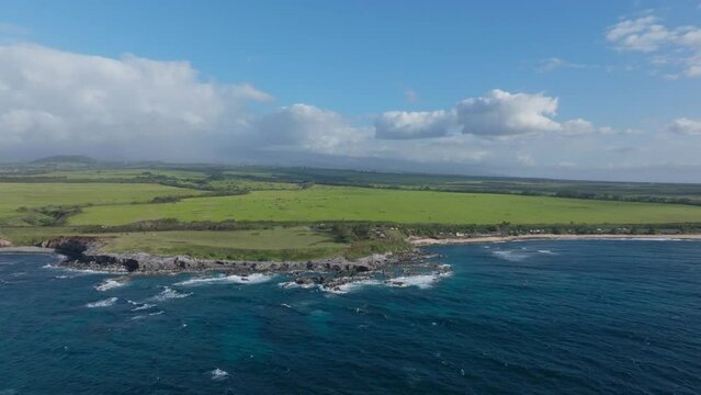 Aerial panoramic establishing coast near Hookipa Maui sloping lowlands on sunny day