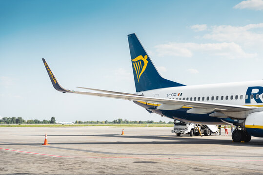RyanAir Boeing 737 (EI-FZD) on a sunny day. Boarding of an aircraft on the apron; regional jet rolling along the taxiway in the background. Boryspil, Ukraine - September 02 2018.