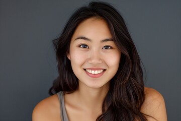 Headshot of Beautiful Smiling Young Asian Woman Looking at the Camera with Joy and Confidence.