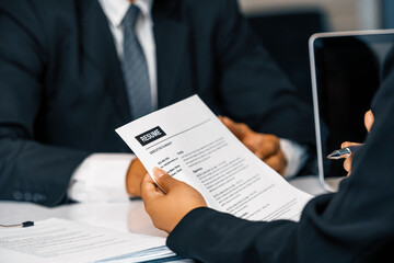 Human resources department manager reads CV resume document of an employee candidate at interview...