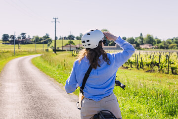 Woman tourist with a bike exploring wine region of Saint-Émilion, Bordeaux, France