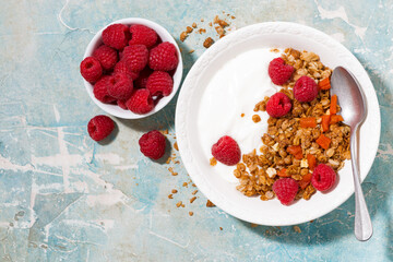 granola with dried apricots, fresh raspberries and yogurt for breakfast, top view