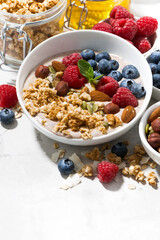 muesli with yogurt and fresh berries for breakfast on white background, vertical closeup