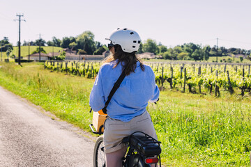 Woman tourist with a bike exploring wine region of Saint-Émilion, Bordeaux, France