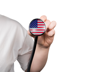 The head of a medical stethoscope in the form of a US flag in a hand (close-up) on a transparent background. US healthcare system concept