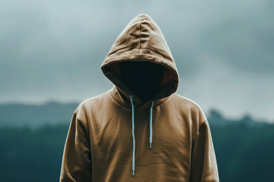 a Caucasian person wearing a hoodie, with the hood concealing their face, presenting an anonymous and mysterious figure. - Powered by Adobe