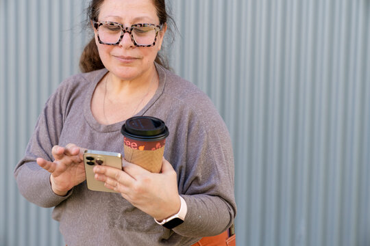 Woman multitasking with cell phone, smartwatch and coffee
