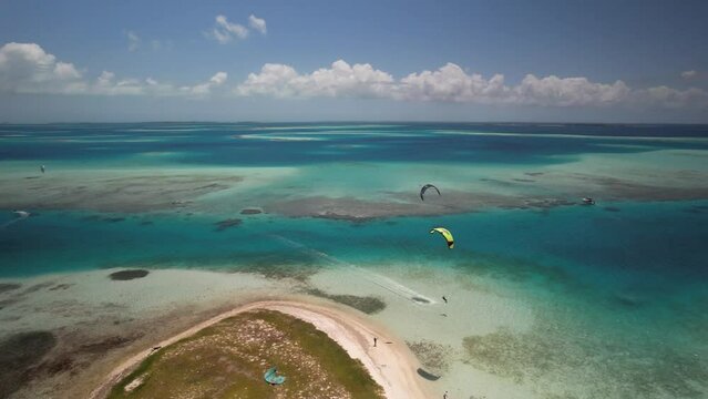A kiter near sandy cay in turquoise caribbean waters, sunny day, aerial view