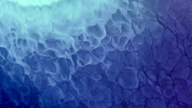 Swirling blue ink creates mesmerizing patterns underwater in a close-up shot