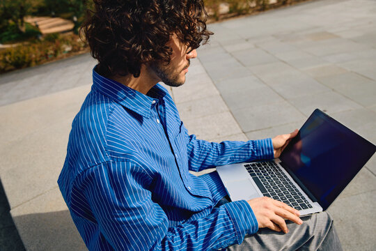 Young creative man working from open space in the city 