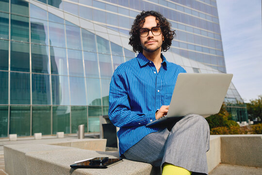 Portrait of a young professional man with a laptop in a business area.