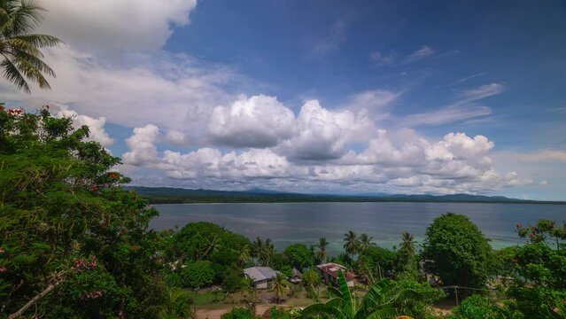 Tropical village coconut palm tree tide South Pacific Ccean bay Wewak East Sepik River Province capital district Papua New Guinea Timelapse clouds sunshine sunny daytime islands Madang Northern Coast