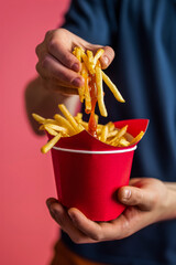 Hands of person holding french fries