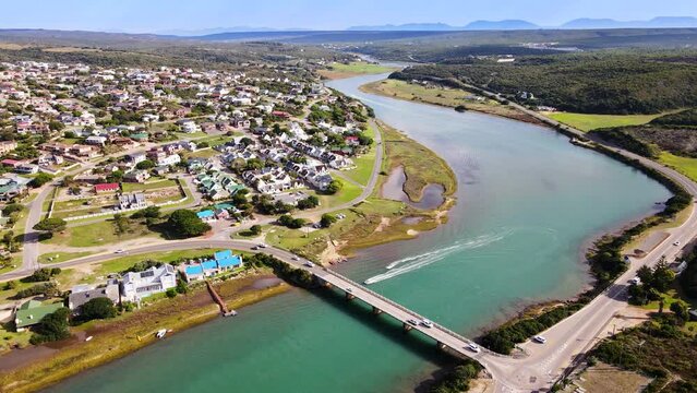 Aerial view of Stilbaai bridge with traffic and leisure crafts on Goukou river