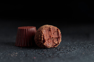 Delicious gourmet chocolate truffles from confectionery, homemade dark chocolate candies on black background