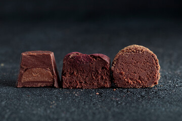 Delicious gourmet homemade dark chocolate candies from confectionery on black background