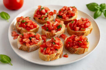 Homemade Bruschetta with Basil and Tomatoes on a Plate, side view.