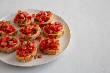 Homemade Bruschetta with Basil and Tomatoes on a Plate, side view. Copy space.
