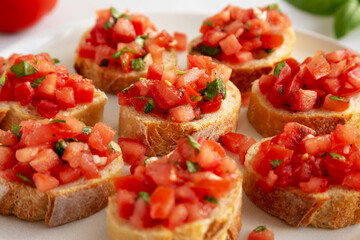 Homemade Bruschetta with Basil and Tomatoes on a Plate, side view.