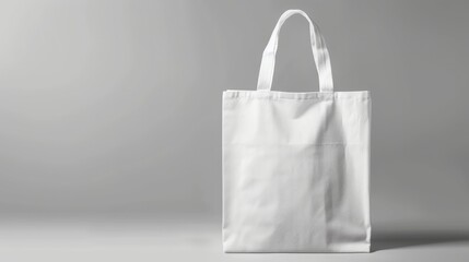 Mockup of a white tote bag against a grey background.


