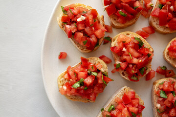 Homemade Bruschetta with Basil and Tomatoes on a Plate, top view.