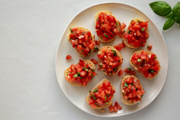 Homemade Bruschetta with Basil and Tomatoes on a Plate, top view. Copy space.