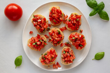 Homemade Bruschetta with Basil and Tomatoes on a Plate, top view.