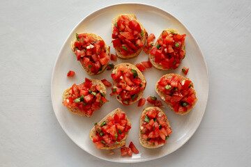 Homemade Bruschetta with Basil and Tomatoes on a Plate, top view.