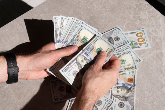 Counting a pile of hundred dollar bills closeup