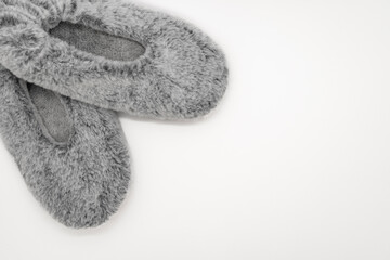 Fluffy gray home slippers isolated on white background. Bed shoes accessory footwear. Top view or flat lay, close-up.