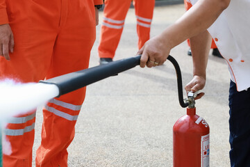 Employees firefighting training, Concept Employees hand using fire extinguisher fighting fire...