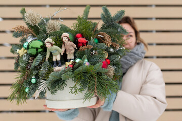 Woman Holding Potted Plant With Christmas Decorations