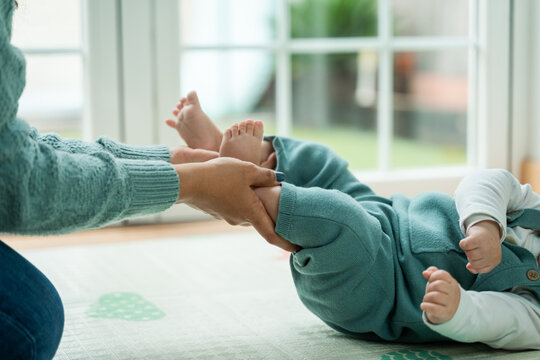 Playful bonding time: baby and parent's hands