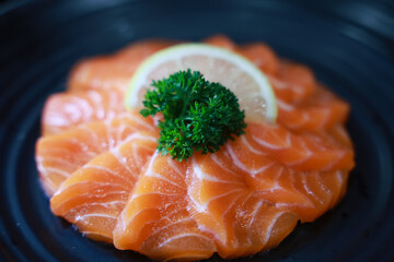 Salmon Sashimi in Japanese buffet restaurant menu. Fresh Sashimi fillet on black plate salmon slices. Salmon sashimi. Asian Food Menu. Seafood sashimi.