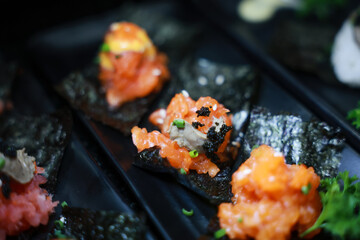 Spicy salmon sushi, Spicy salmon rolls in dark plate.