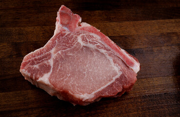 Pork entrecotes lie on a wooden cutting board. Pork . Piece of meat .