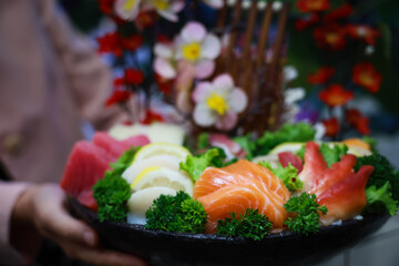 Authentic Japanese style sashimi plate. Fresh sashimi. Different types of seafood placed on a black...