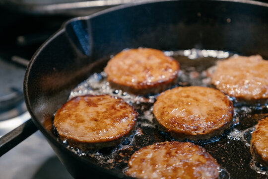 Vegan Sausage Patties Cooking in Cast Iron Skillet